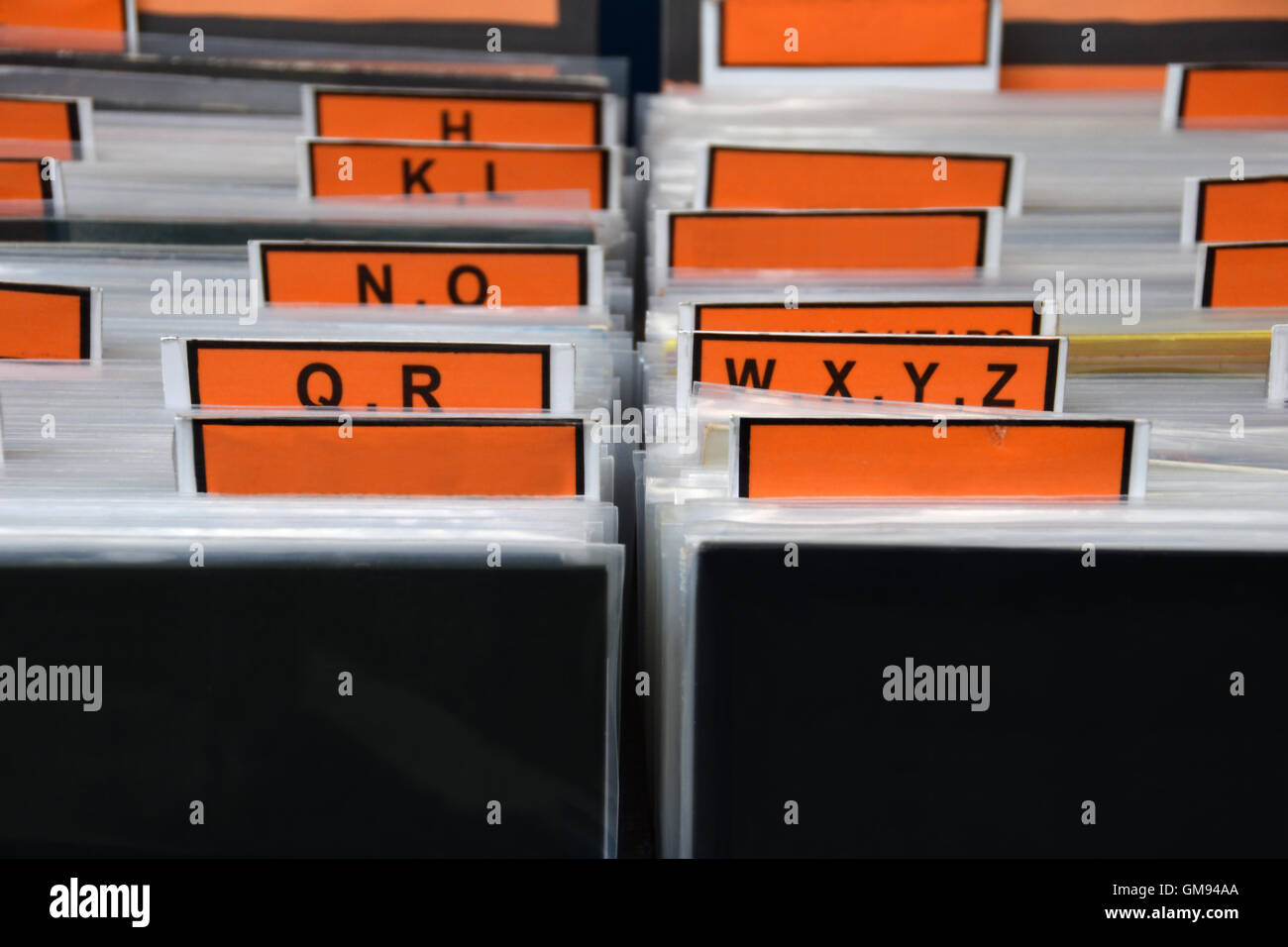 Los discos de vinilo archivados en orden alfabético con separadores de plástico. Almacenamiento de la colección de música de fondo abstracto. Foto de stock
