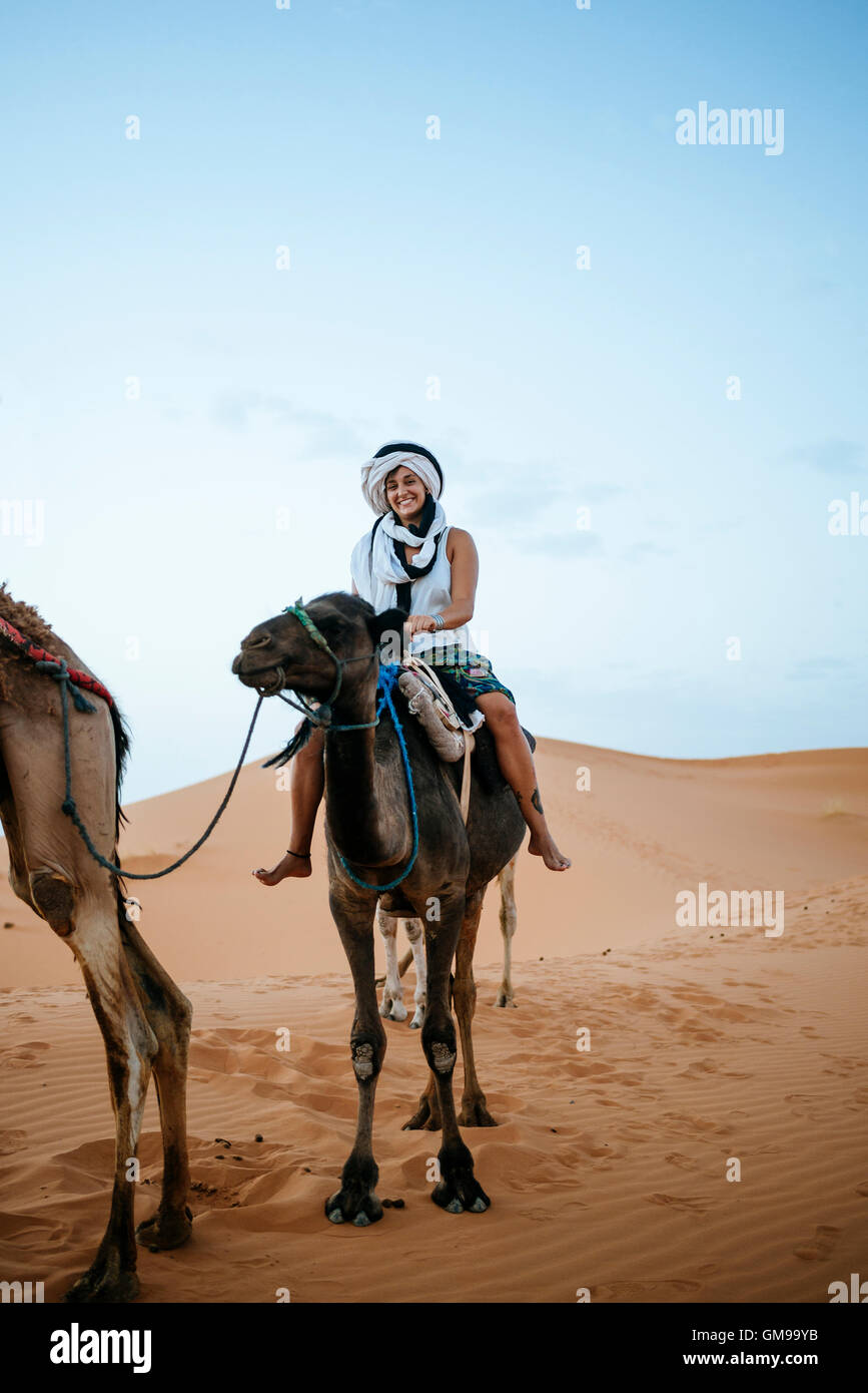 Mujer con turbante montando un camello en el desierto Fotografía de stock -  Alamy