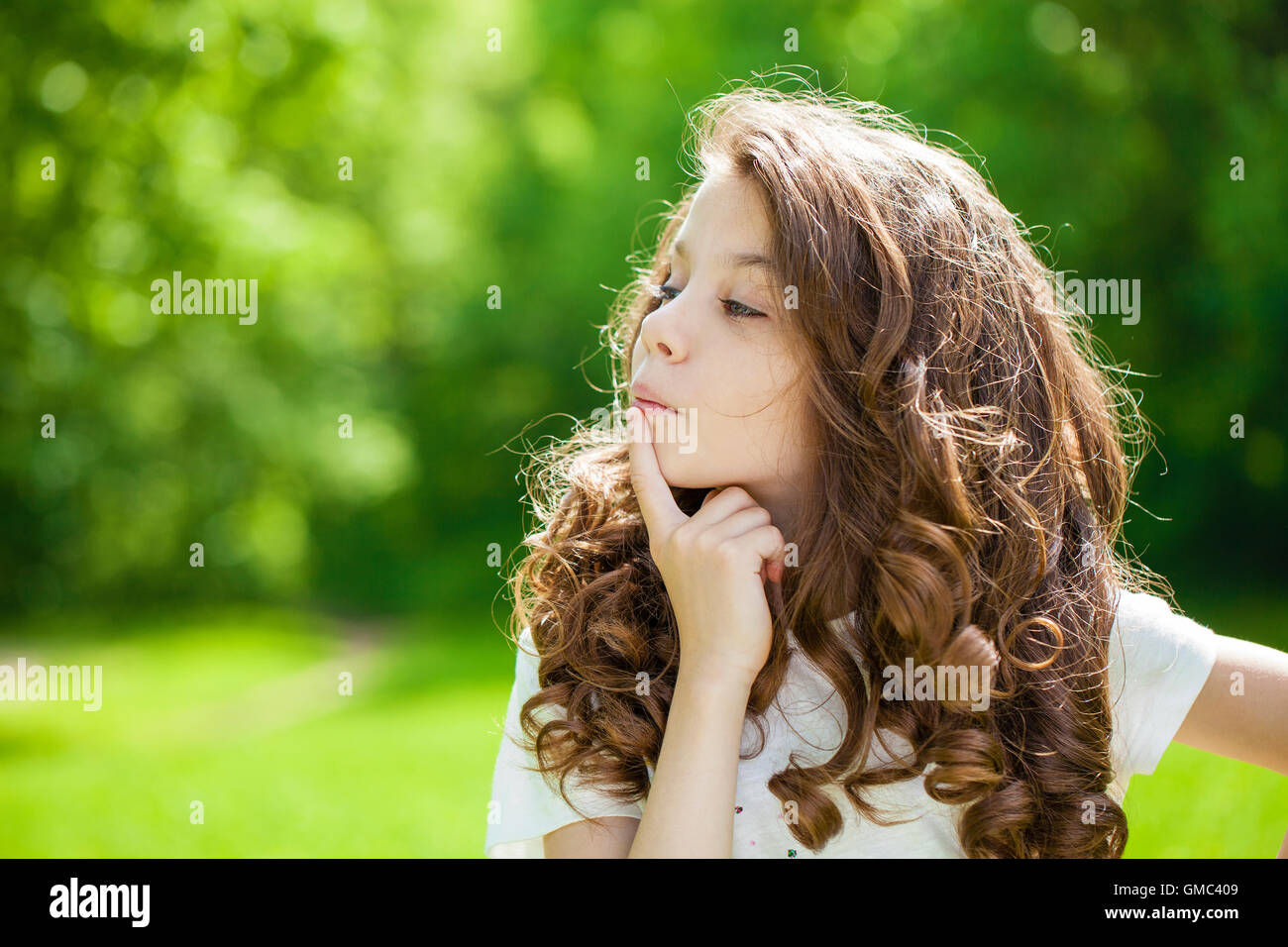 Retrato de una joven y bella niña en el fondo del parque de verano Foto de stock