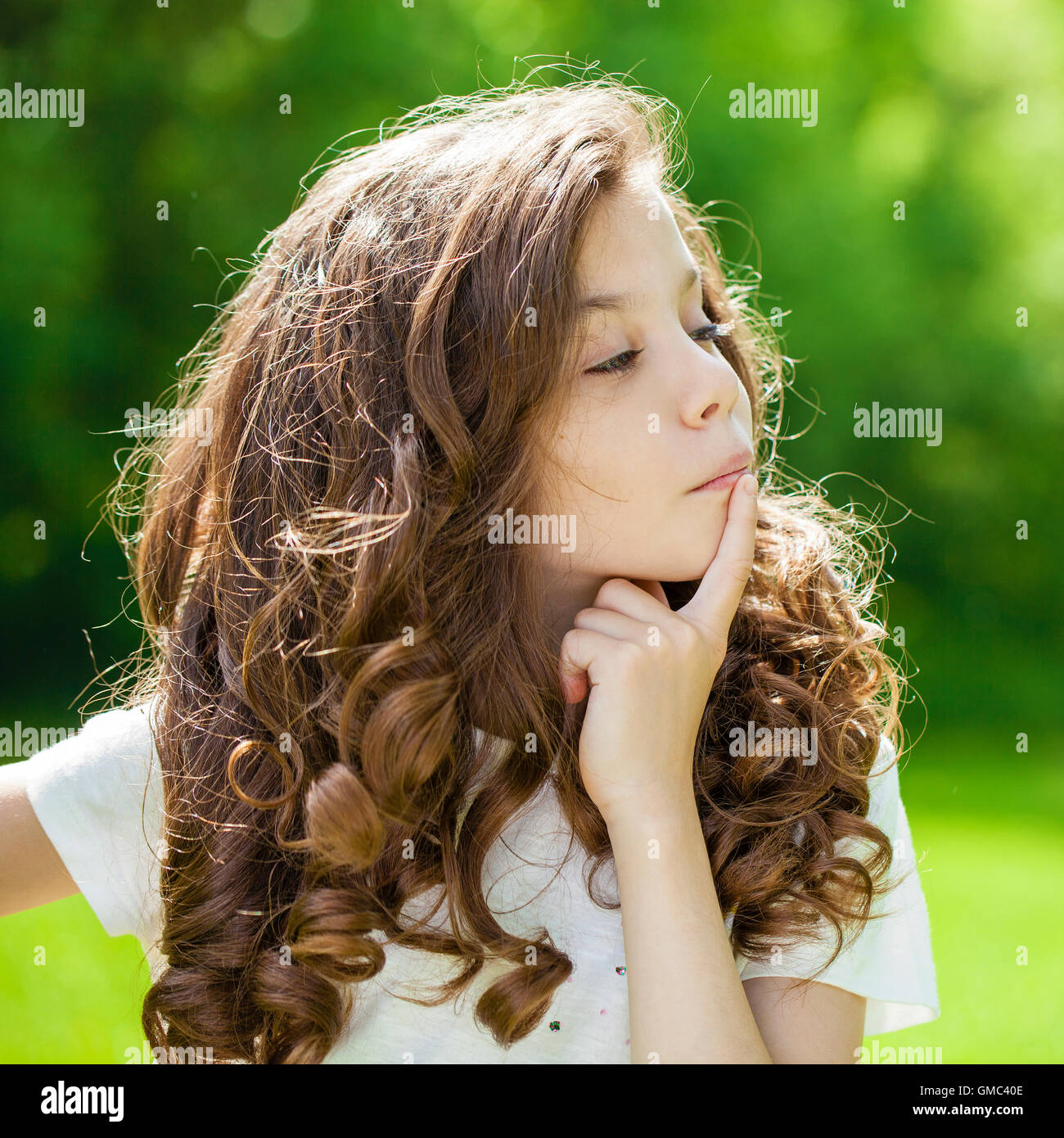 Retrato de una joven y bella niña en el fondo del parque de verano Foto de stock