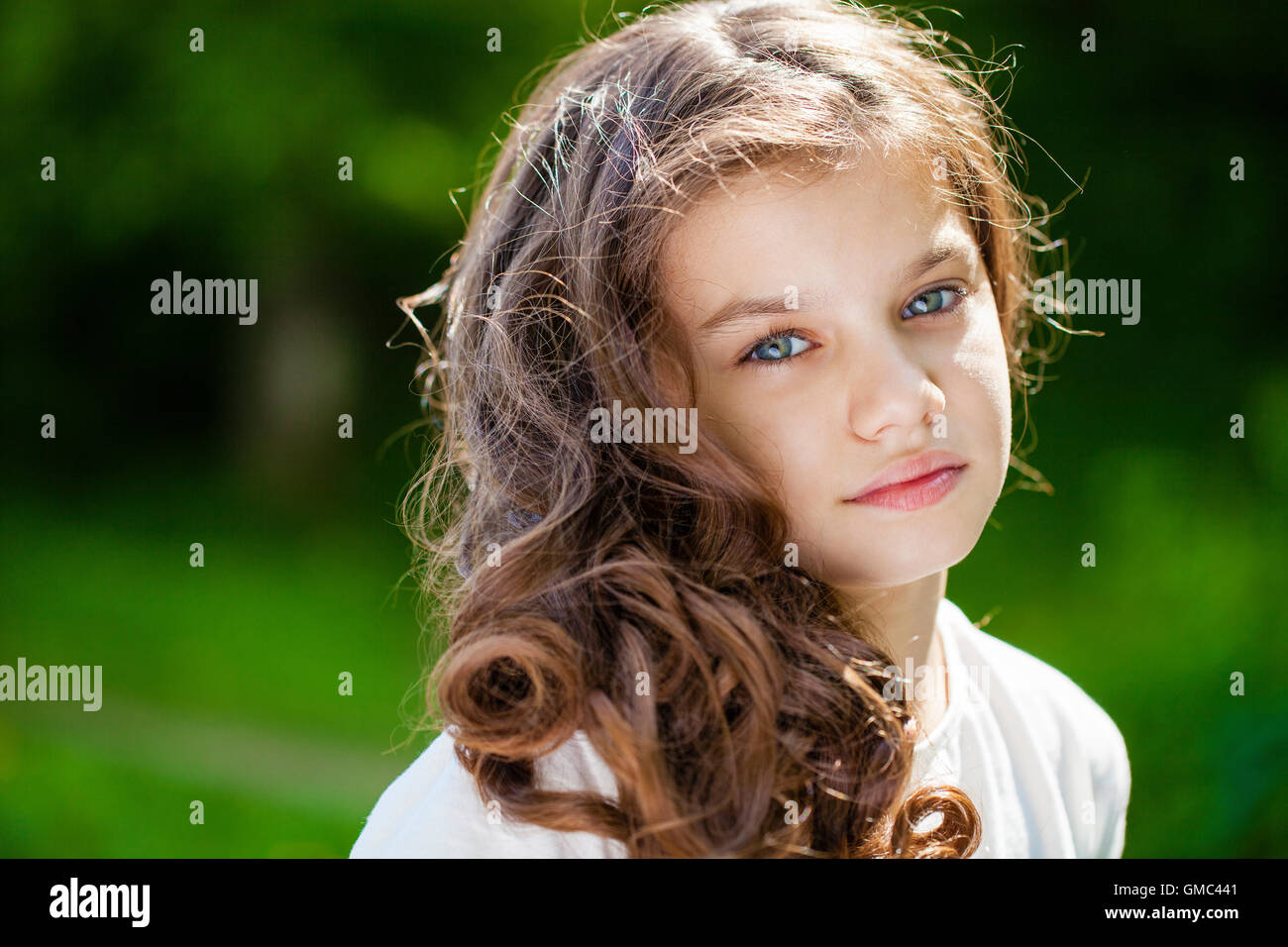 Retrato de una joven y bella niña en el fondo del parque de verano Foto de stock