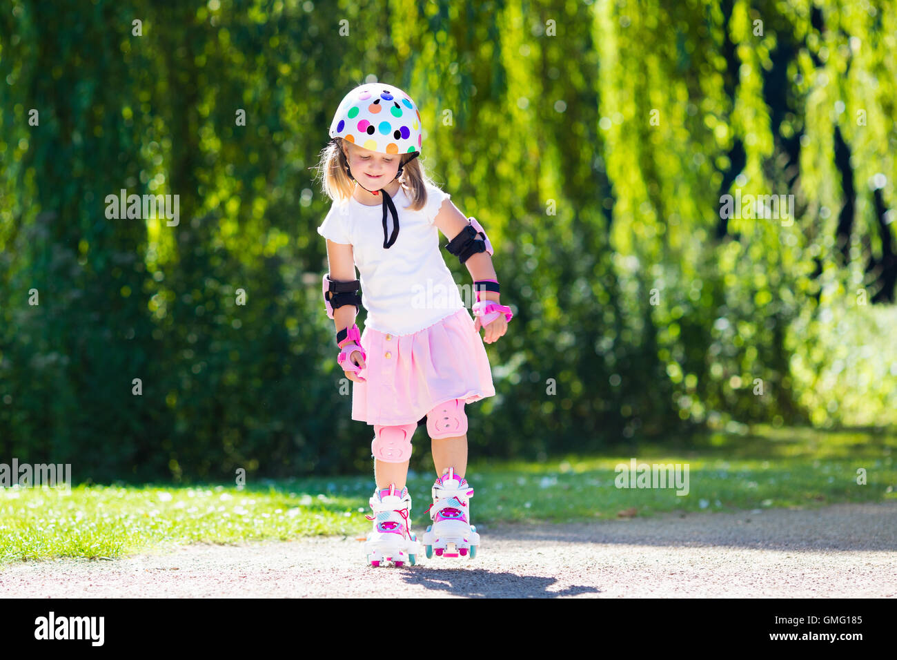 Niña aprendiendo a patines en el parque soleado de verano. Un niño llevaba  protección rodilleras y coderas, muñequeras y casco de seguridad SEGURO DE  ROLLE Fotografía de stock - Alamy