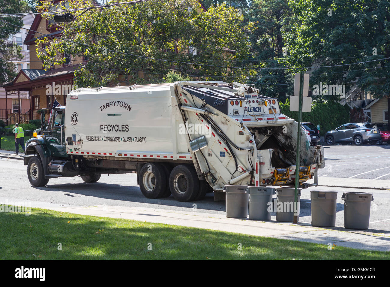 Los trabajadores sanitarios recopilar reciclables, utilizando un camión recolector de carga trasera en una calle en Tarrytown, Nueva York. Foto de stock