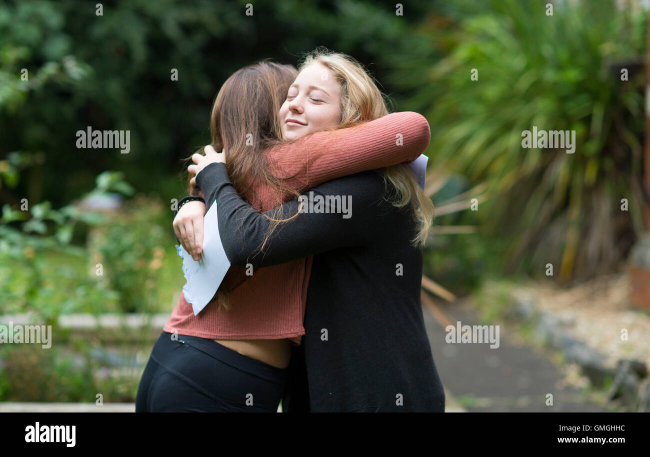 Dos mujeres niñas celebran su día los resultados de los exámenes GCSE en una escuela en Swansea, Gales del Sur. Foto de stock