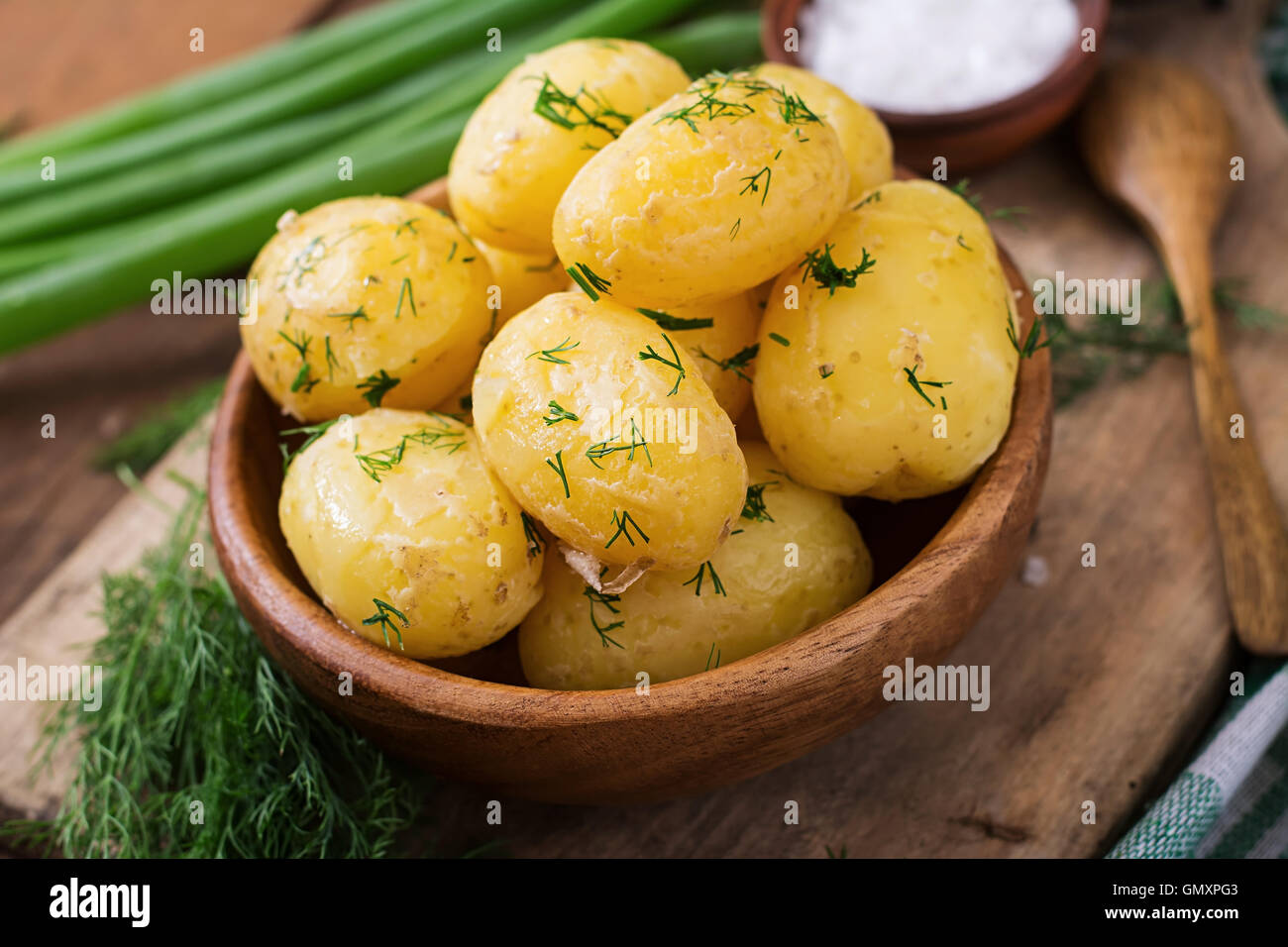 Patatas hervidas condimentadas con eneldo y mantequilla. Foto de stock