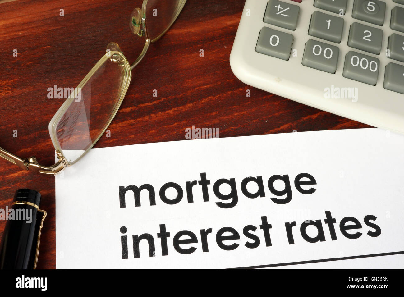 Papel con palabras las tasas de interés hipotecario sobre un fondo de madera. Foto de stock