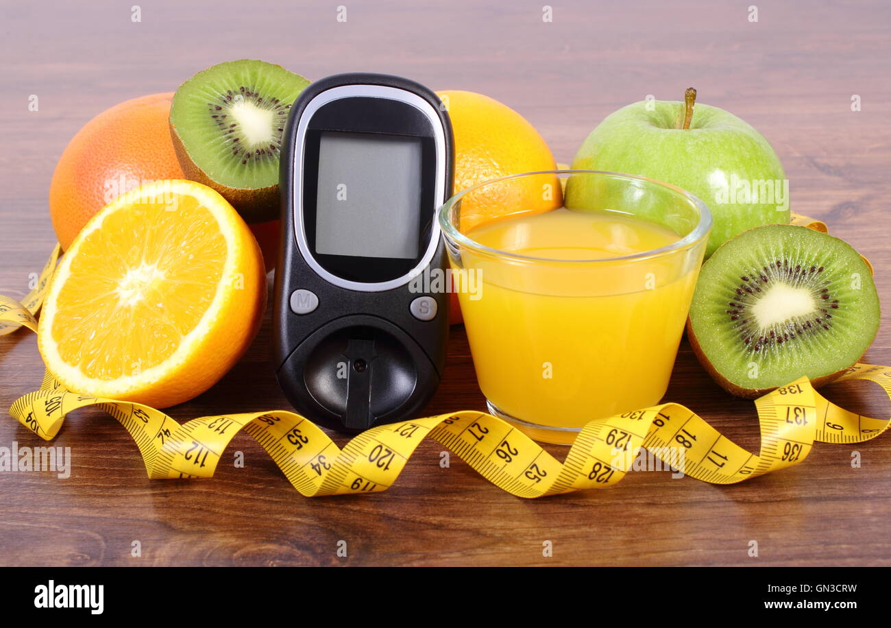 Medidor de glucosa, frescas frutas maduras, vaso de jugo de naranja y cinta  de medir, pomelo, kiwi, Apple concepto de diabetes y saludable Fotografía  de stock - Alamy