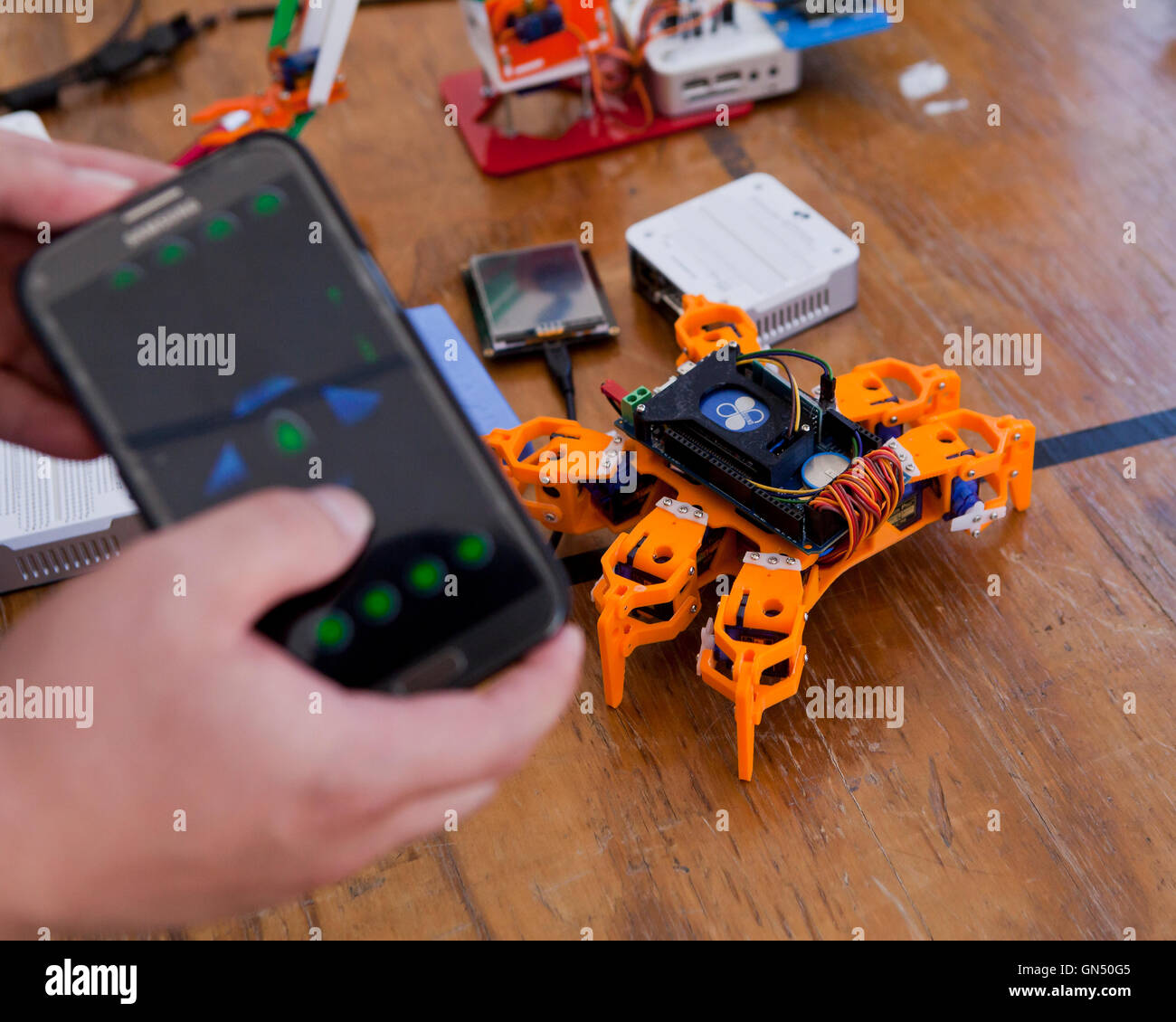 El hombre controlar robot de juguete con teléfono móvil ap vía Bluethooth - EE.UU. Foto de stock