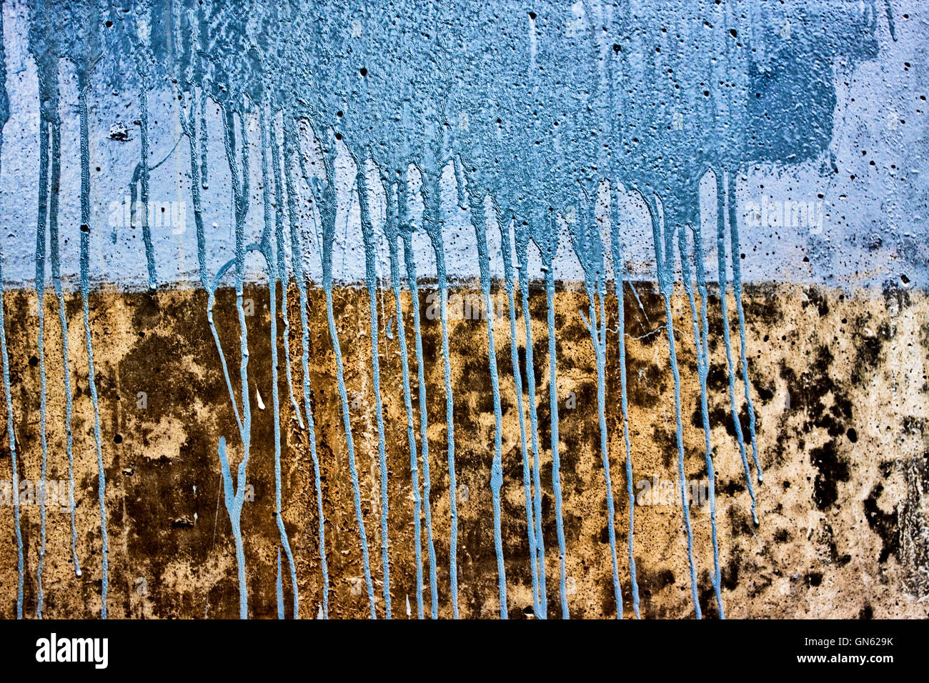 Muro de hormigón con gotas de pintura azul Foto de stock