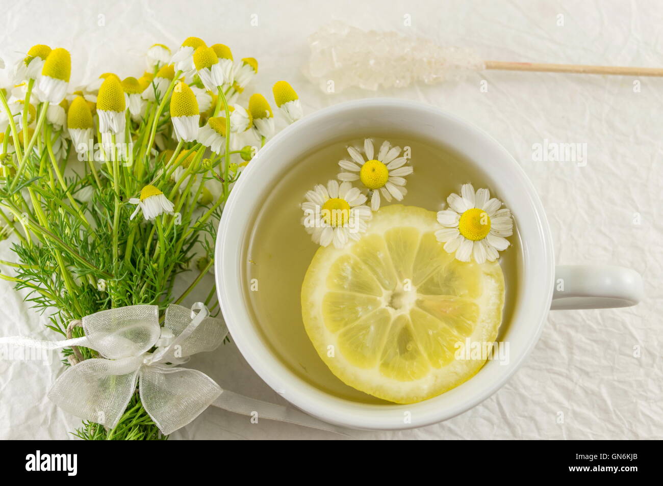 Un té de manzanilla con rodajas de limón y flores Fotografía de stock