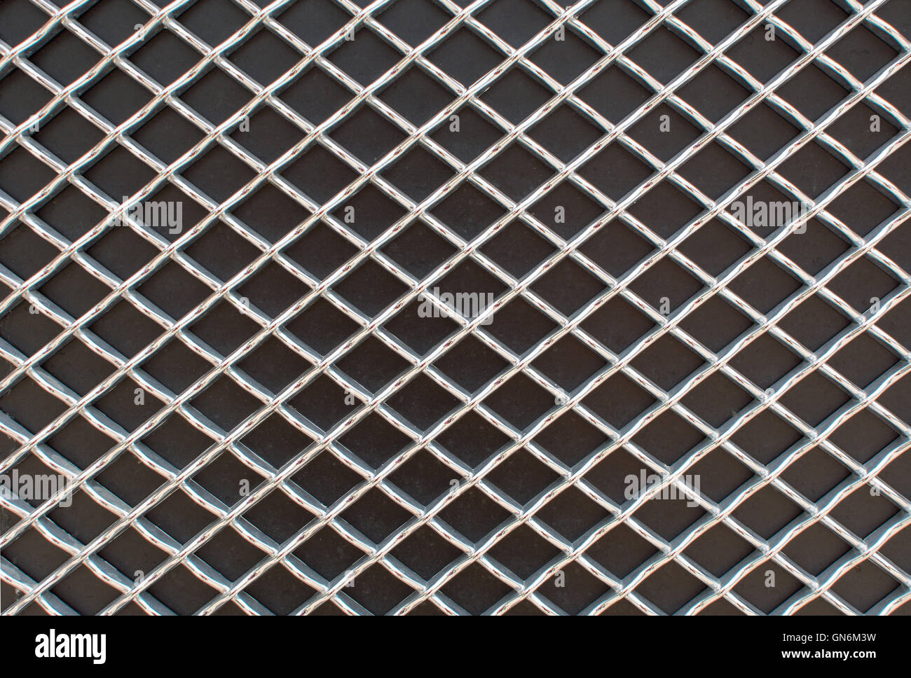 Fotografía de rhombus rejilla metálica patrón sobre superficie negra Foto de stock