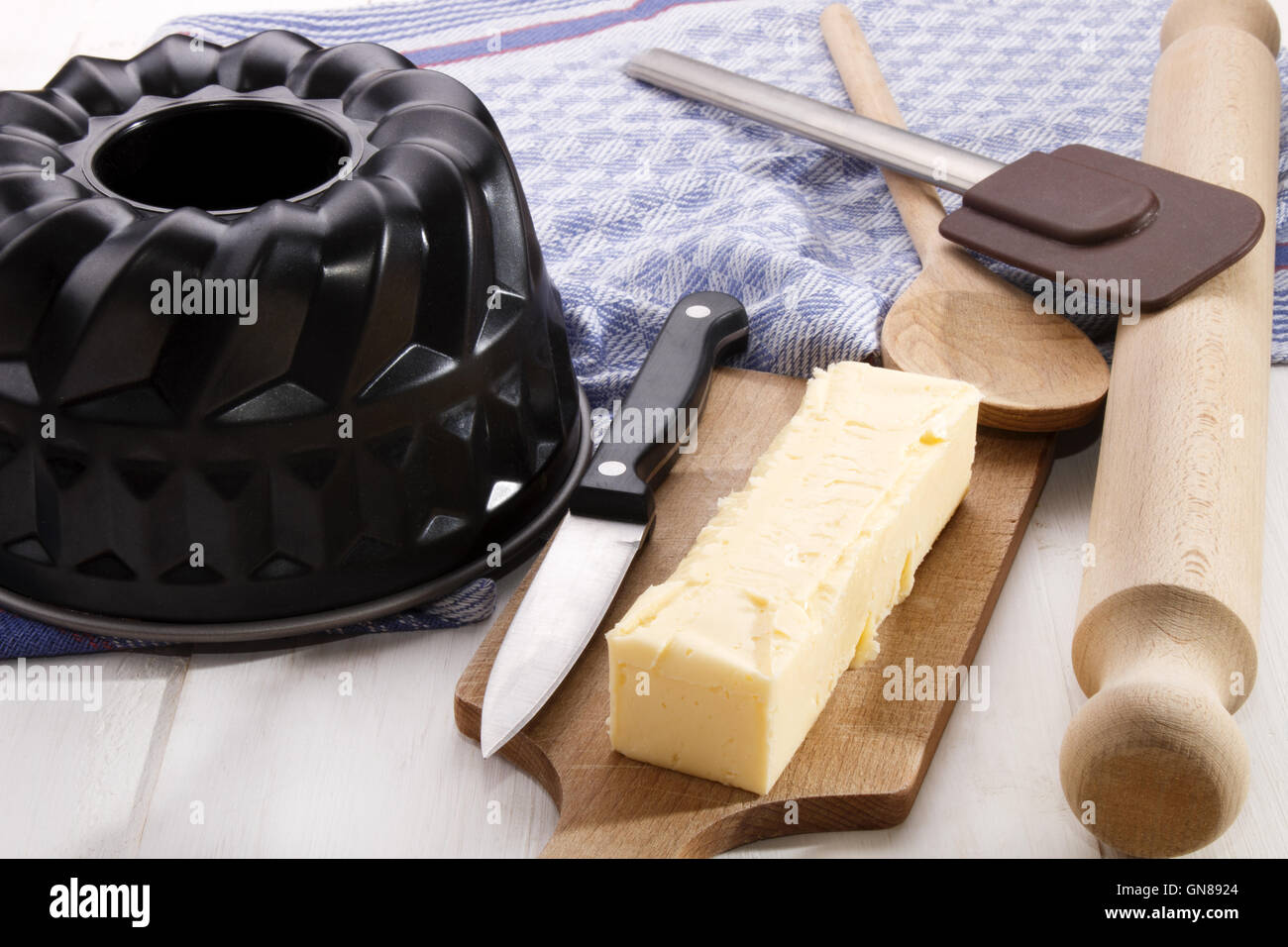 125 gramos de mantequilla stick, ideal para hornear, con un cuchillo sobre una tabla de madera Foto de stock