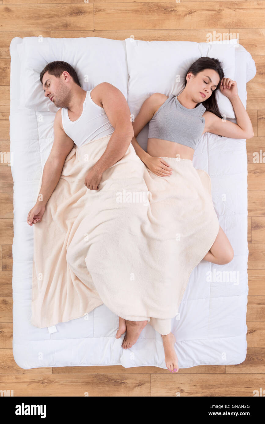 Buen hombre y mujer durmiendo juntos en la cama Fotografía de stock - Alamy