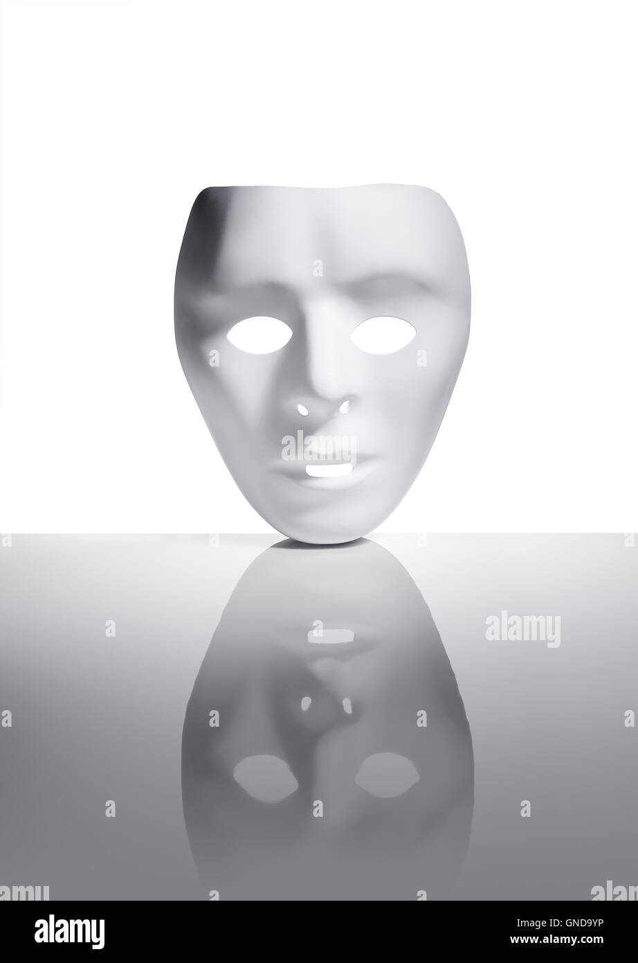 Máscara de plástico blanco en la superficie reflectante. Foto de stock