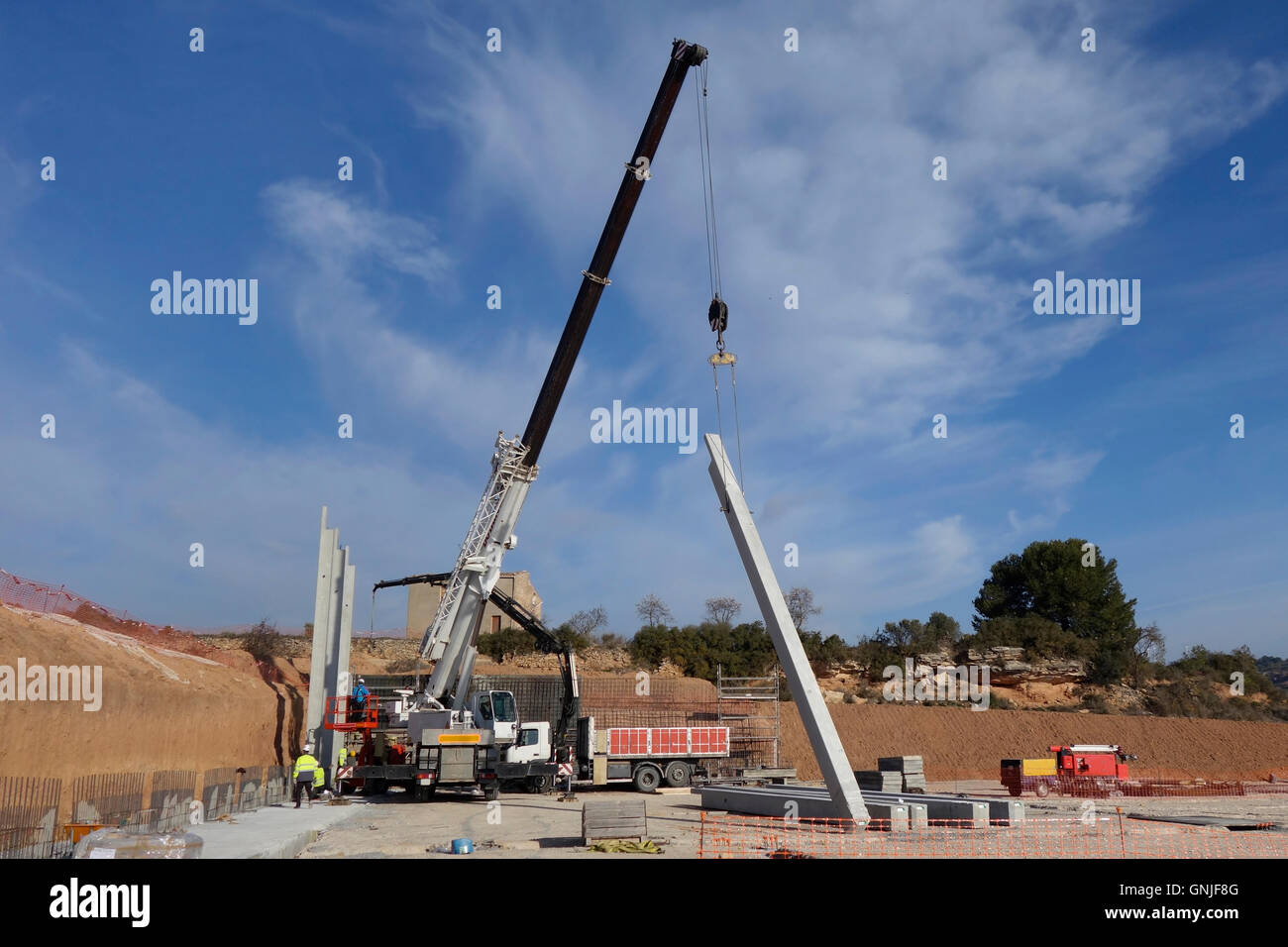 Grúa grande trabajando con pilares de hormigón, en las obras de construcción Foto de stock