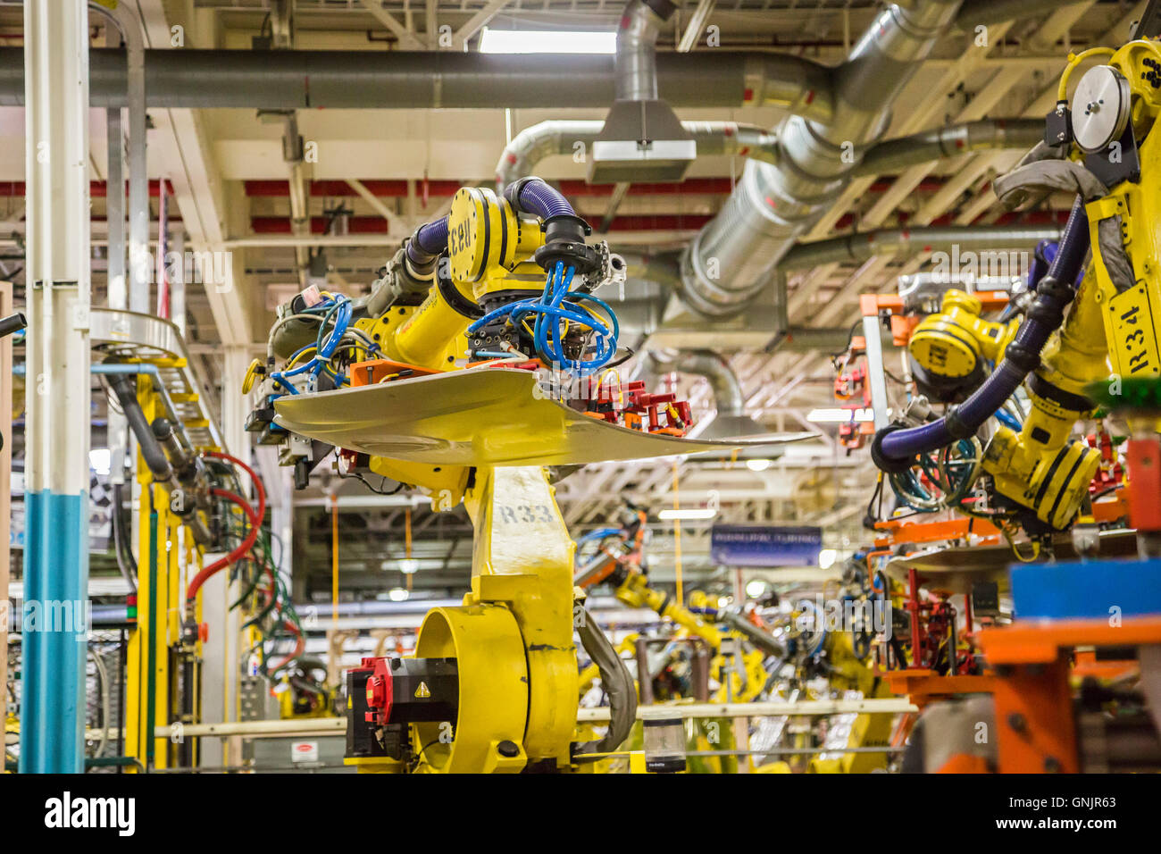 Sterling Heights, Michigan - Robot R33 mueve el capó de un automóvil a un nuevo puesto de trabajo como piezas están soldadas. Foto de stock