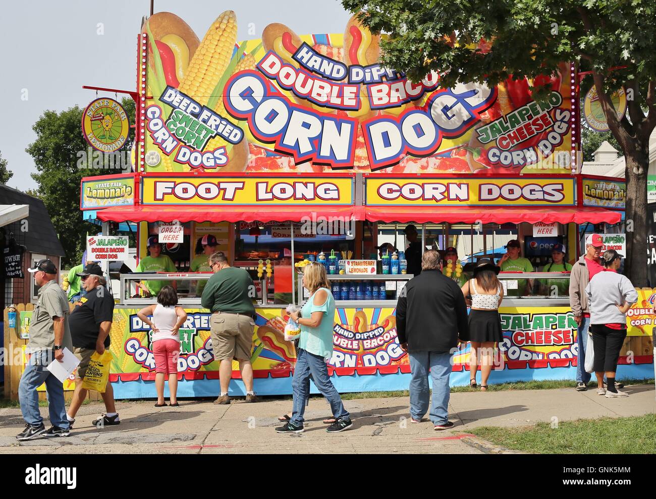 Fairgoers delante de un perro de maíz stand en la Feria del Estado de Minnesota. Foto de stock