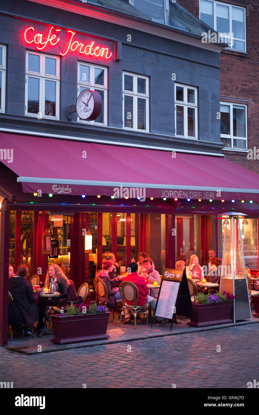 Los comensales comer al fresco en el Cafe Jorden, un pavimento cafetería Plaza Torvet en Lille en el antiguo Barrio Latino de Aarhus, Dinamarca Foto de stock
