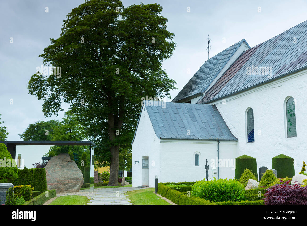 Jelling Gudstjeneste Kirke (la iglesia) y piedras de Jelling estelas rúnicas, cuna del cristianismo en Dinamarca Foto de stock