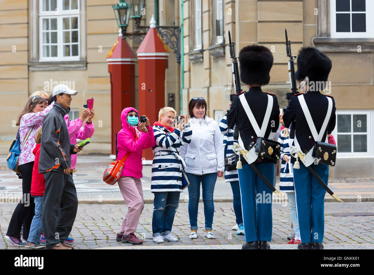 Los turistas tomando fotografías del ejército danés sentry soldado uniformado en el Real Palacio de Amalienborg, en Copenhague, Dinamarca Foto de stock
