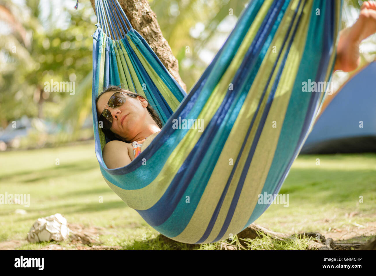 Mujer tomando una siesta en una hamaca en la playa Foto de stock