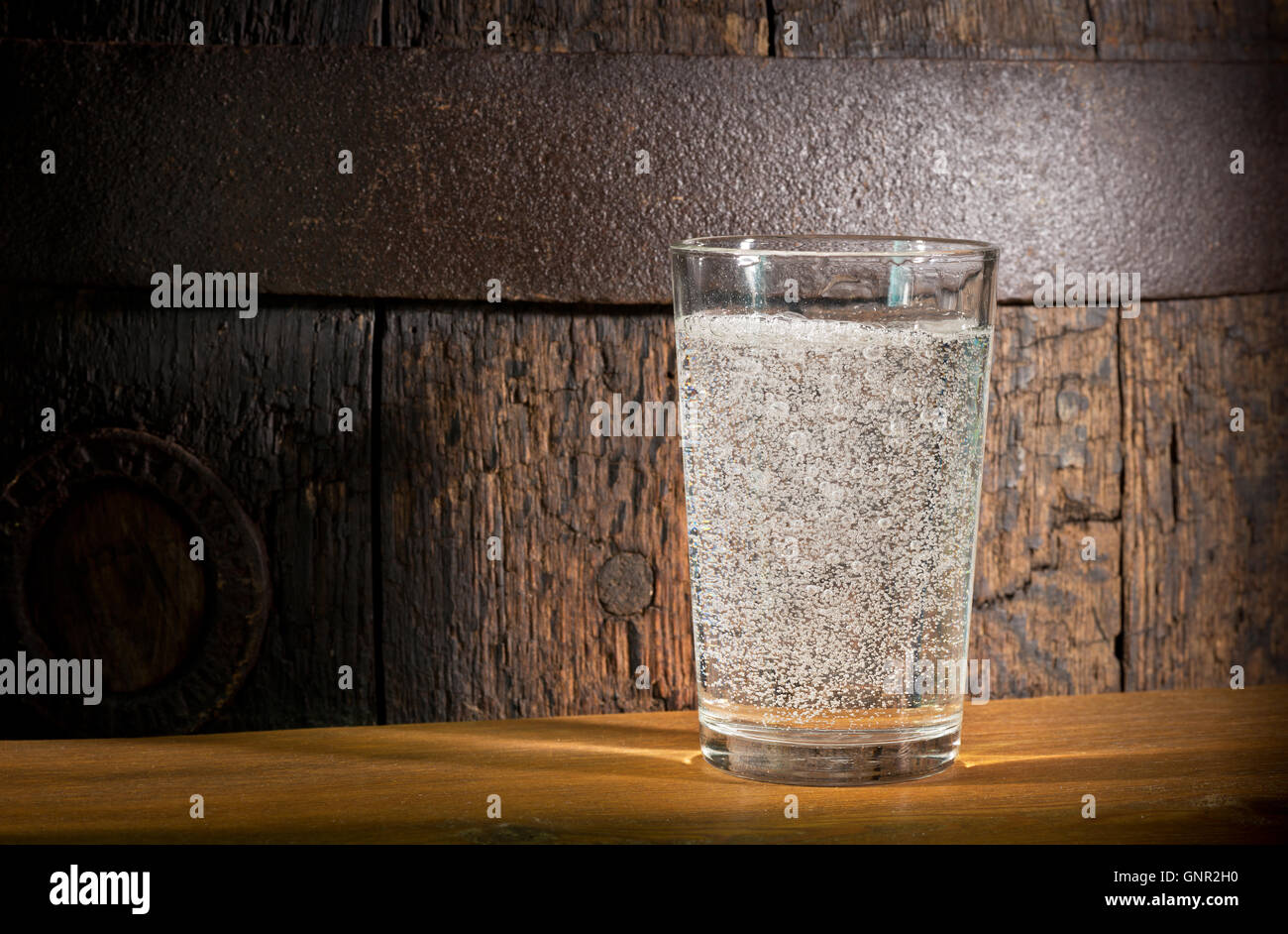Un vaso de agua mineral en el fondo oscuro Foto de stock