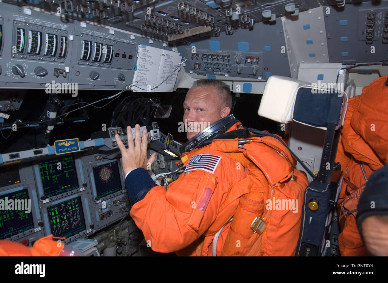 Piloto del transbordador espacial Endeavour, Doug Hurley vistiendo su traje naranja de lanzamiento y entrada en la cubierta de vuelo de avance durante la misión STS-127 el 15 de julio de 2009 en la órbita de la tierra. Foto de stock
