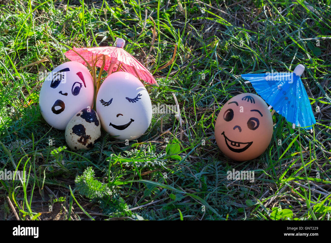 Gracioso huevos imitando a los padres blancos y de color bebé versicolored amigo masculino Foto de stock