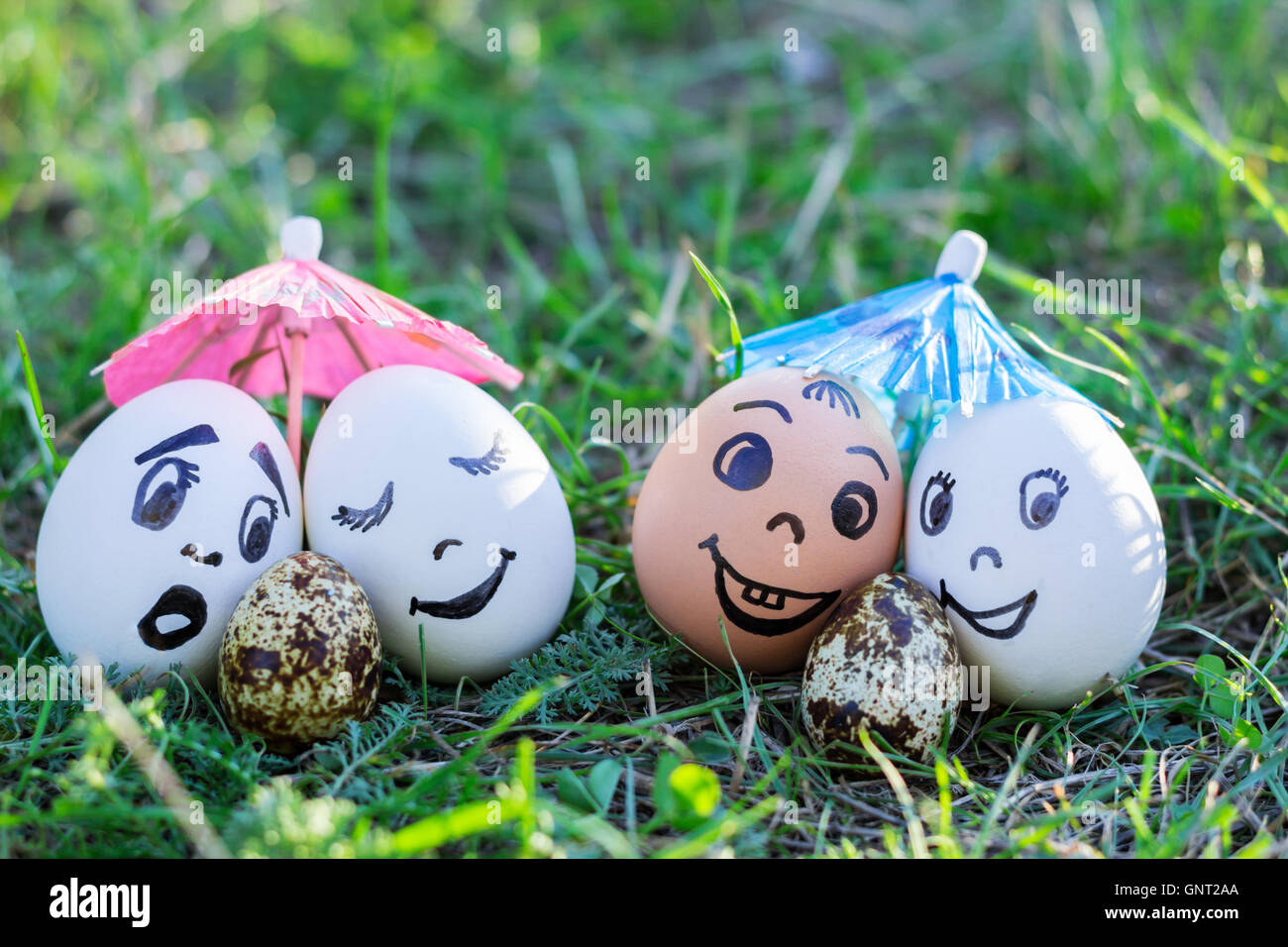 Gracioso huevos imitando y sorprendió a dos parejas de padres blancos versicolored bebé Foto de stock