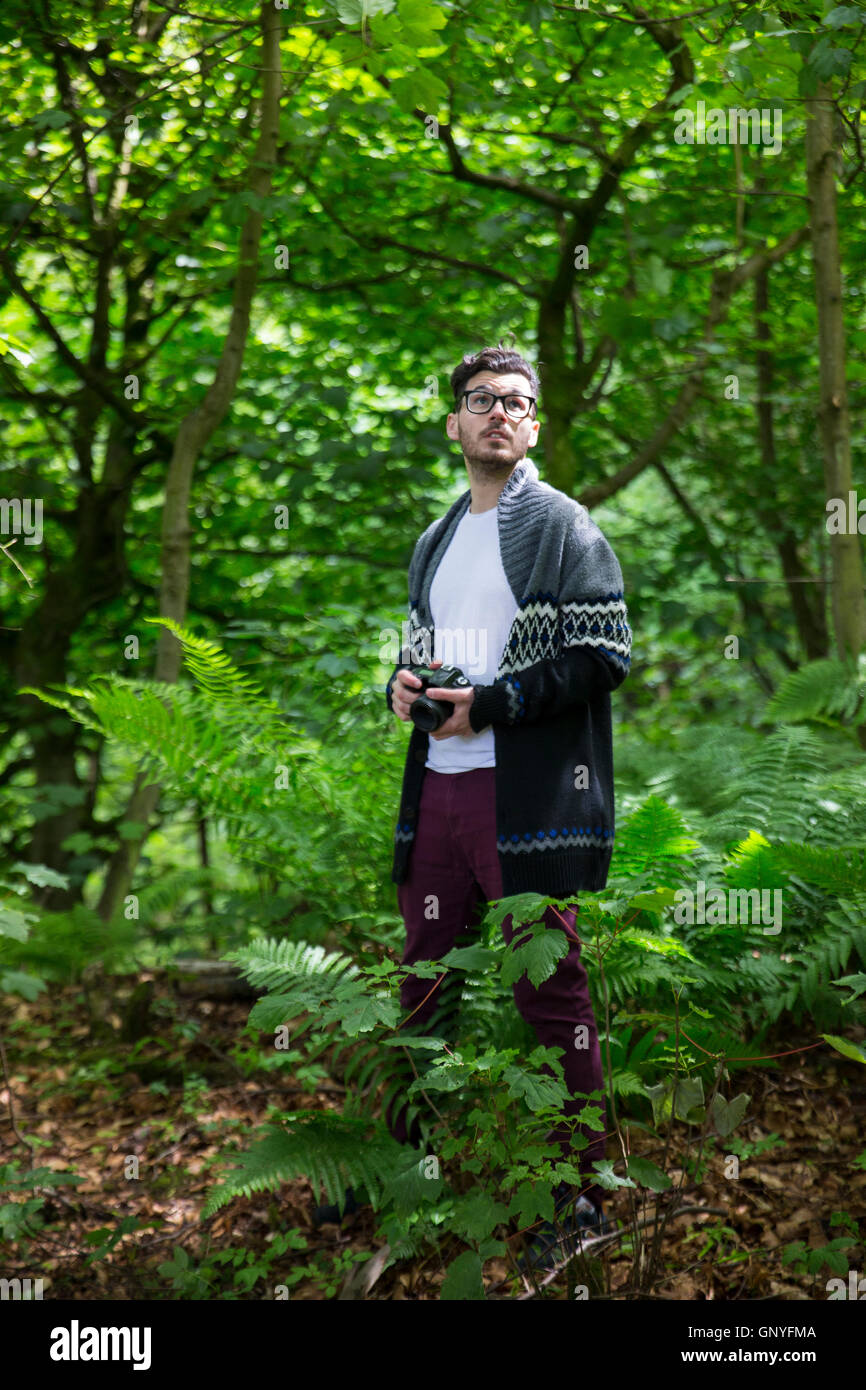 Retrato del hombre tomando fotos con una DSLR en un bosque. Fotógrafo del Cáucaso fuera de tiro con cámara digital. Foto de stock