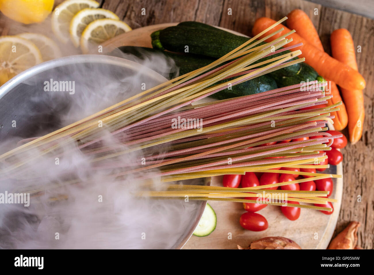 Colorido italiano spaghetti y vegetales frescos como ingredientes típicos de la cocina italiana sana Foto de stock