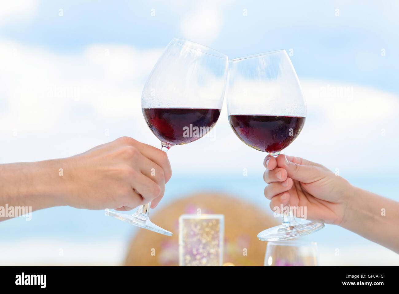 Par bebiendo vino en una cena romántica en el twighlight, closeup. El enfoque selectivo, profundidad de campo Foto de stock
