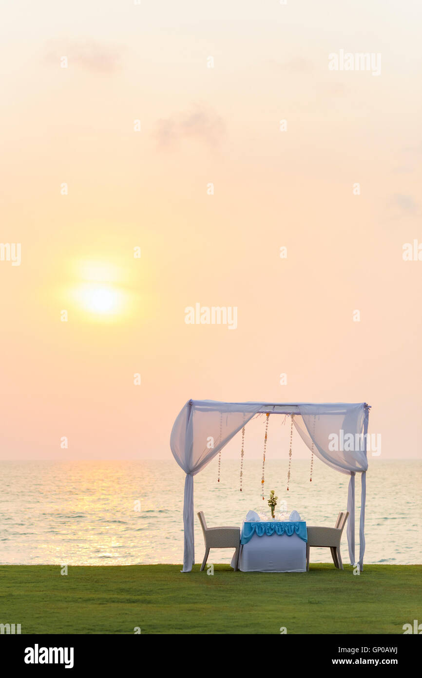 Cena romántica en la playa al anochecer. Foto de stock