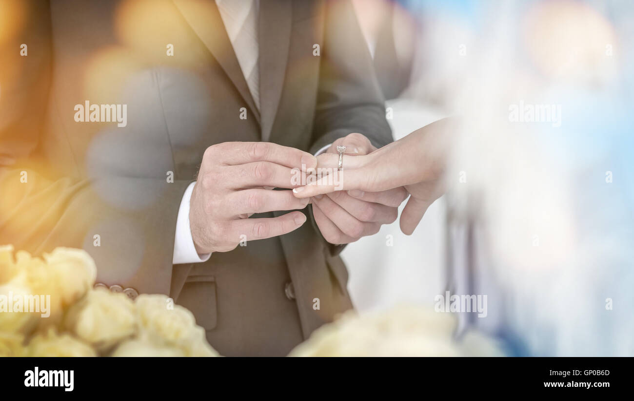 El novio llevaba un anillo de boda a la novia en la boda. Foto de stock