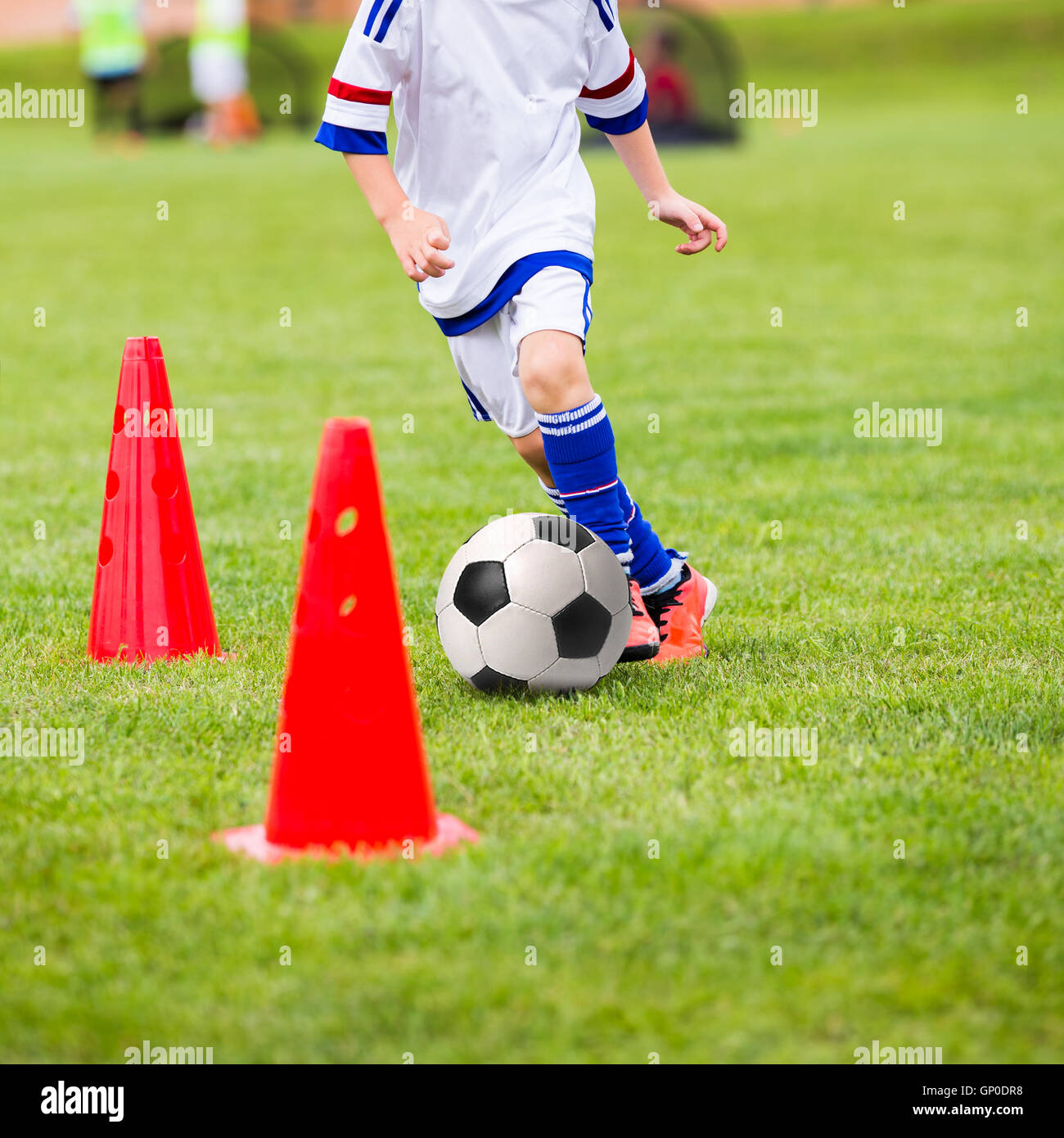 Niño jugando al fútbol. Sesión de entrenamiento de fútbol para niños. Los  muchachos es el entrenamiento con pelota y bolardos sobre el césped  Fotografía de stock - Alamy