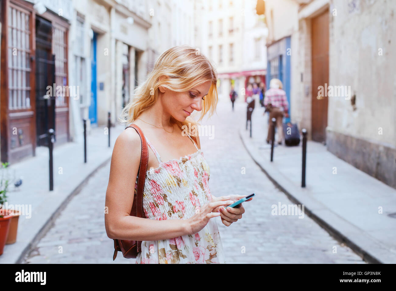 Mujer con móviles en la calle, en la aplicación de teléfono inteligente Foto de stock