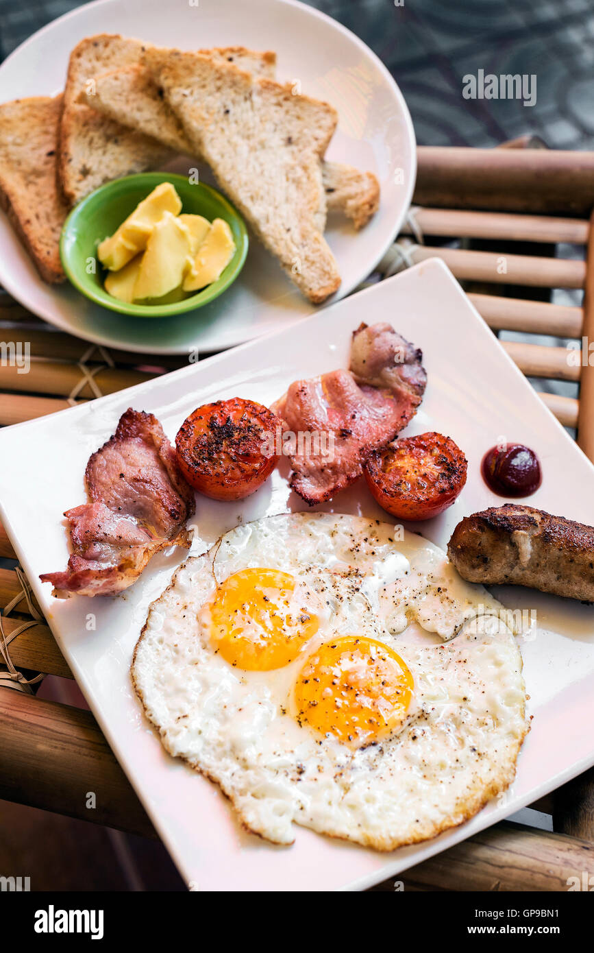 Inglés británico clásico desayuno con huevos fritos bacon y salchichas tomate tostadas set Foto de stock