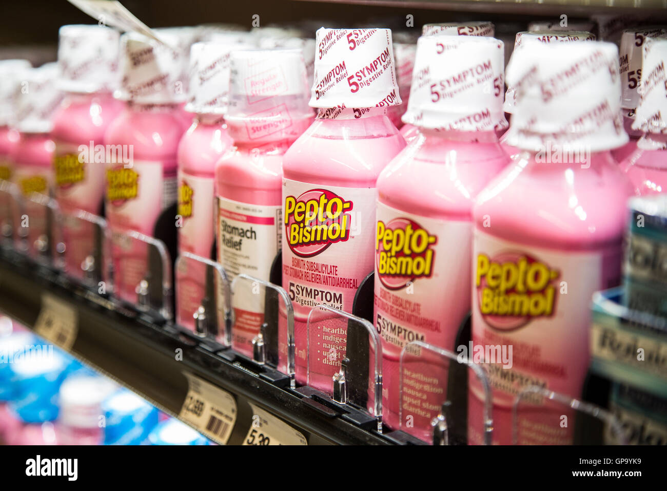 Una fila de Pepto-Bismol para venta en una estantería de una farmacia Foto de stock
