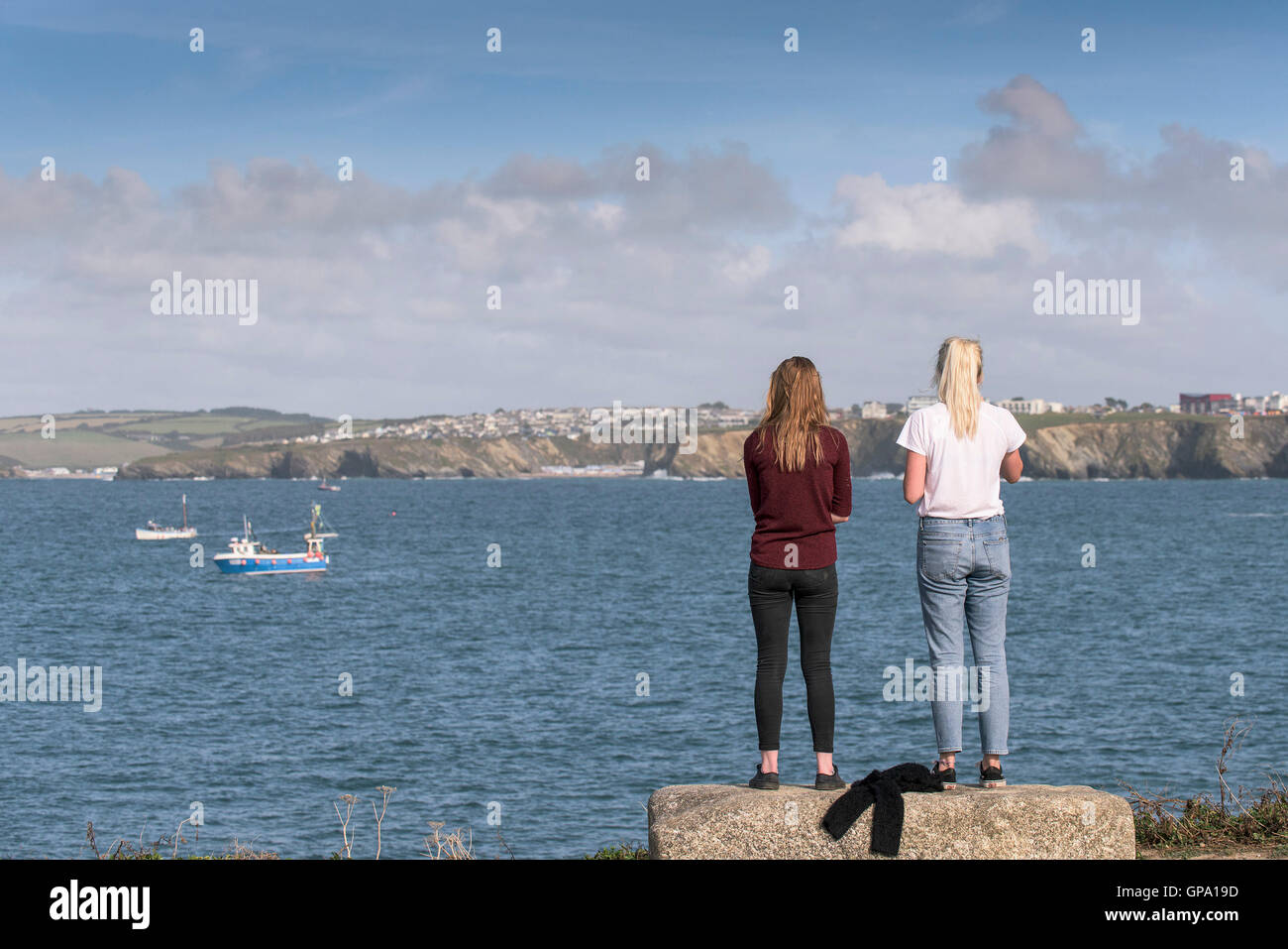 Dos turistas stand y disfrutar de las vistas sobre la bahía de Newquay en Cornualles. Foto de stock