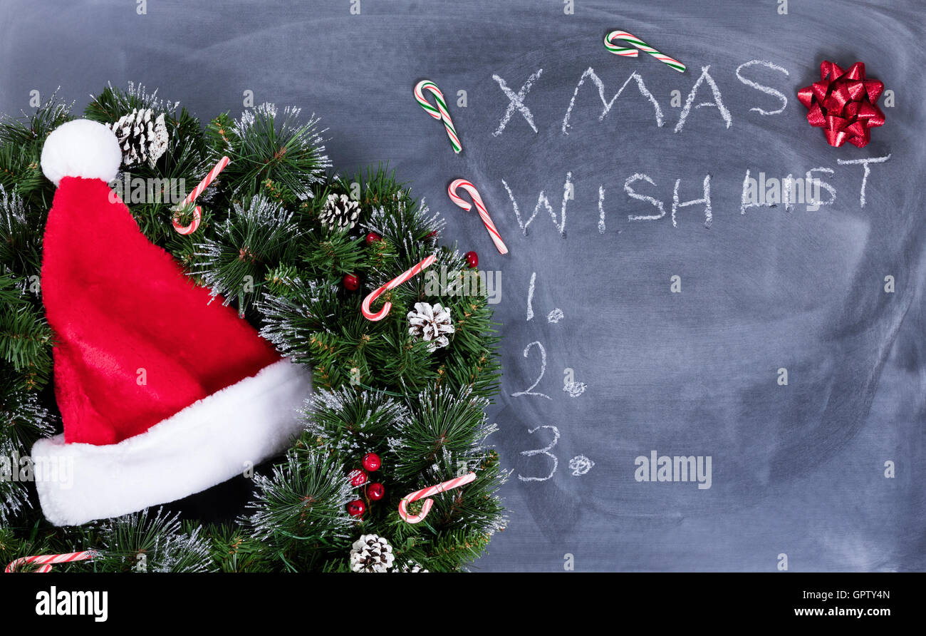 Corona, Santa pac, don arco y bastones de caramelo en borrarse pizarra con  lista de deseos de Navidad escrito a bordo Fotografía de stock - Alamy