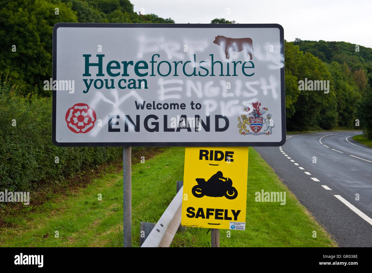 Una ola de anti-graffiti inglés ha aparecido en las señales de la carretera cerca de heno-on-Wye en la frontera de Gales de Inglaterra. Herefordshire Bienvenido a Inglaterra, Gales sin cerdos en inglés Foto de stock