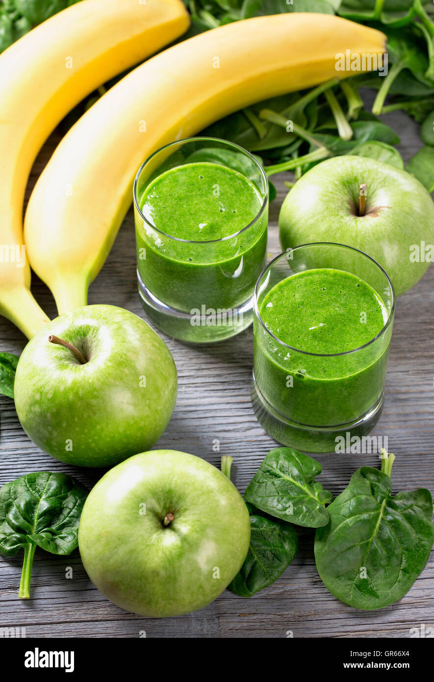 Batido verde con espinacas y plátano en vidrio Foto de stock