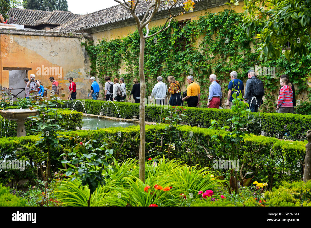Los visitantes pasear por los jardines de la Alhambra, declarado Patrimonio de la Humanidad por la Unesco, Granada, España Foto de stock