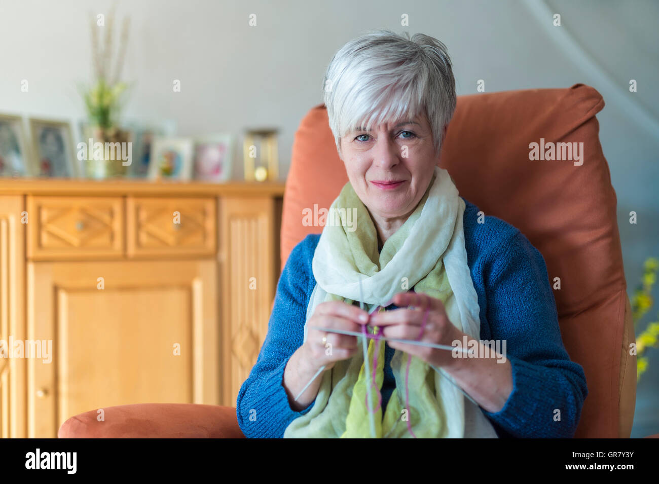 Un alto cargo de la Mujer sentada con tejidos en su silla en el Salón. Foto de stock