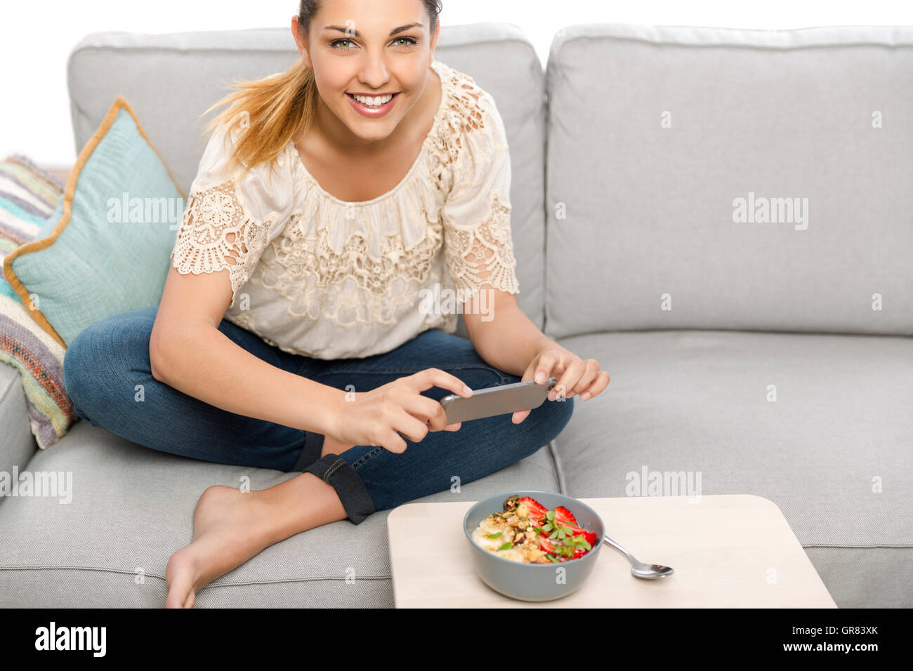 Mujer sentada en la cama listo para comer y hablar a su alimento de imagen Foto de stock