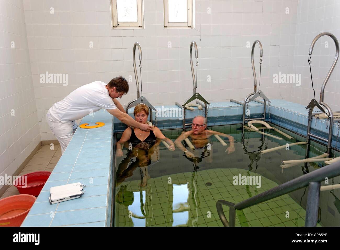 Senior Citizen Pareja con terapeutas en peso en el baño Spa Cegled Foto de stock