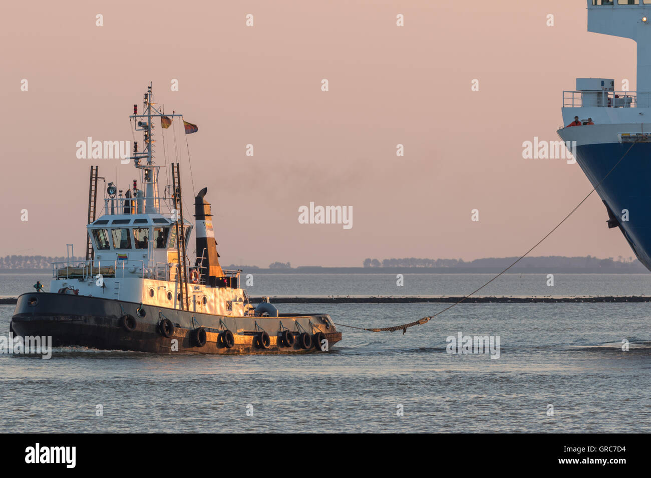 Remolcador tirando de un ferry en el puerto de Emden, Ostfriesland Foto de stock