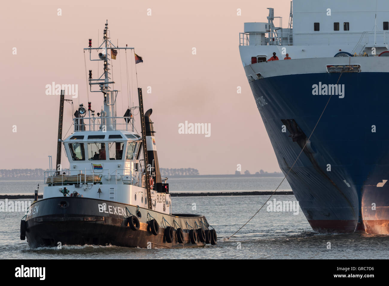 Remolcador tirando de un ferry en el puerto. Foto de stock