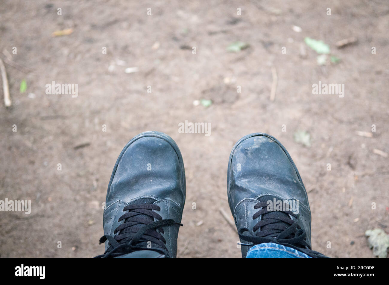 Mirando hacia los pies a lo largo de un camino fangoso Foto de stock
