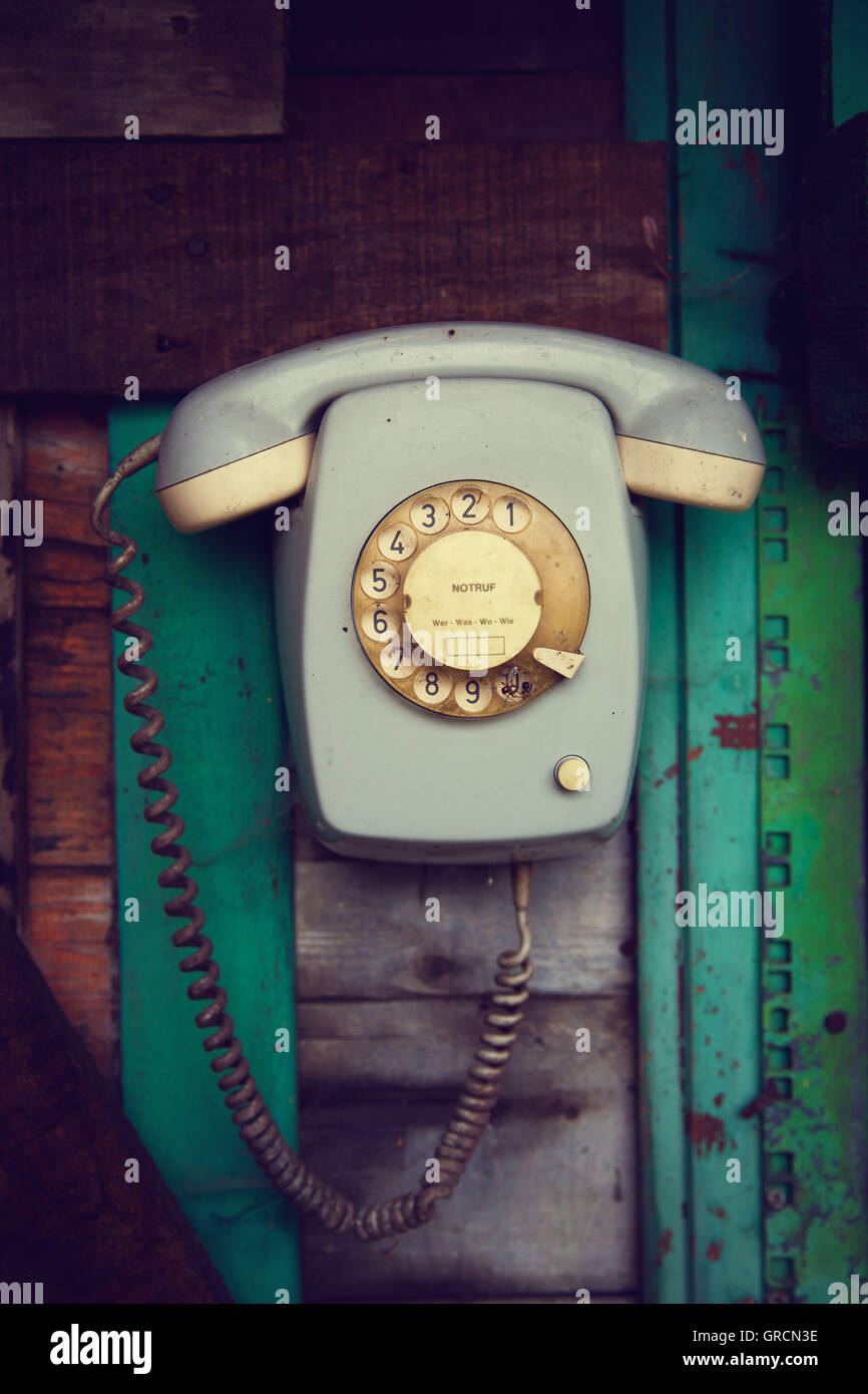 Analógico antiguo teléfono giratorio en una pared de madera Foto de stock